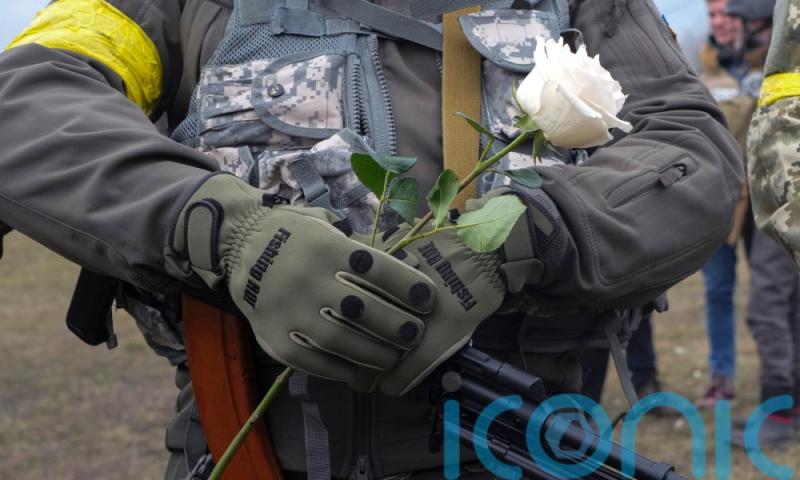Ukrainian soldiers hold flowers as volunteer troops marry at Kyiv checkpoint